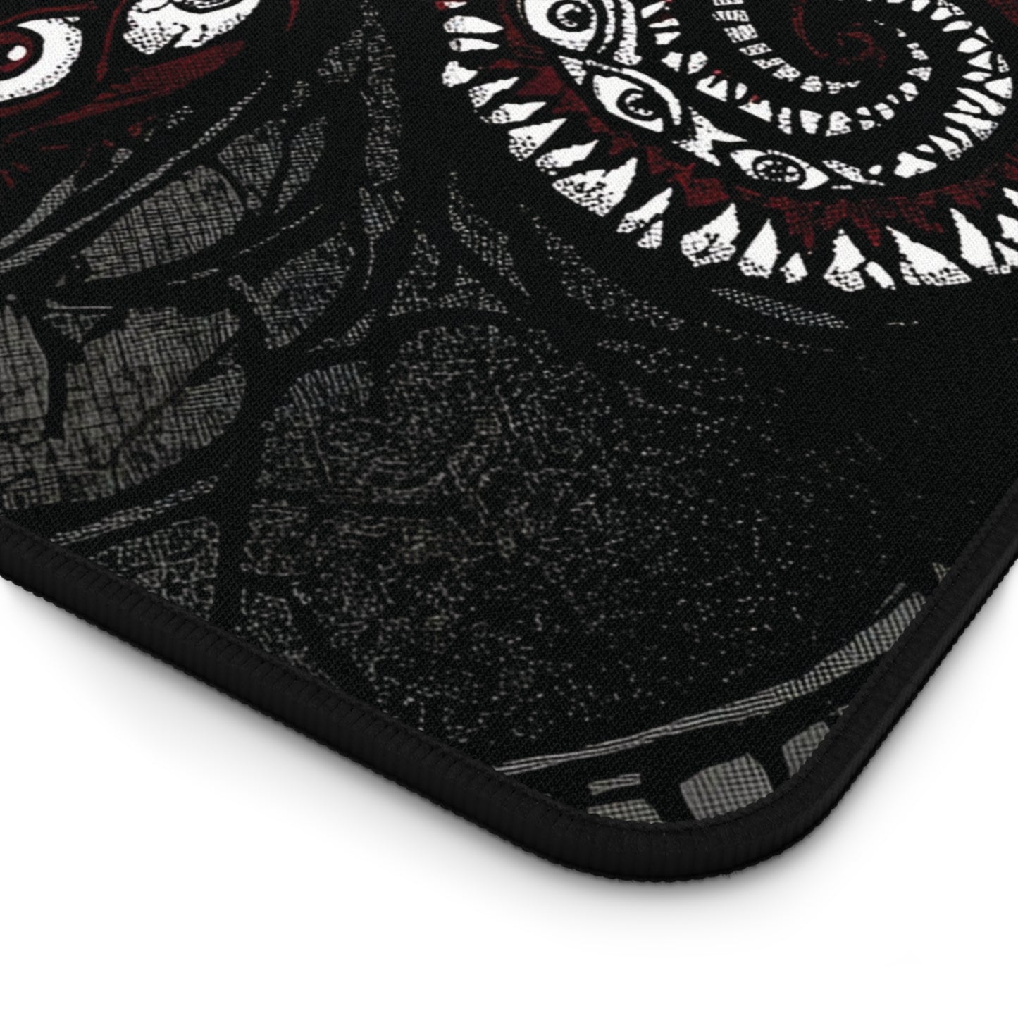 Corner detail of black desk mat with white tentacle pattern and black stitched edge