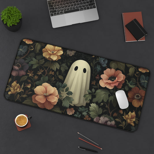 Rectangular desk mat with black edging, dark floral print and pale ghost in center