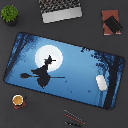 Rectangular blue desk mat with flying witch silhouette under moon graphic, rounded edges