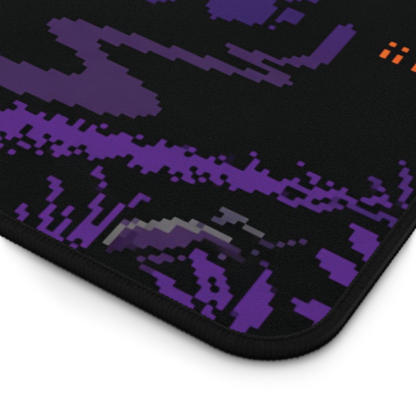 Rectangular desk mat close-up: black base with purple pixel pattern and stitched edge