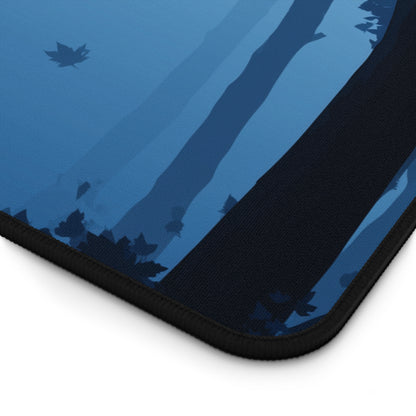 Blue desk mat corner with witch-and-moon artwork and black stitched edge