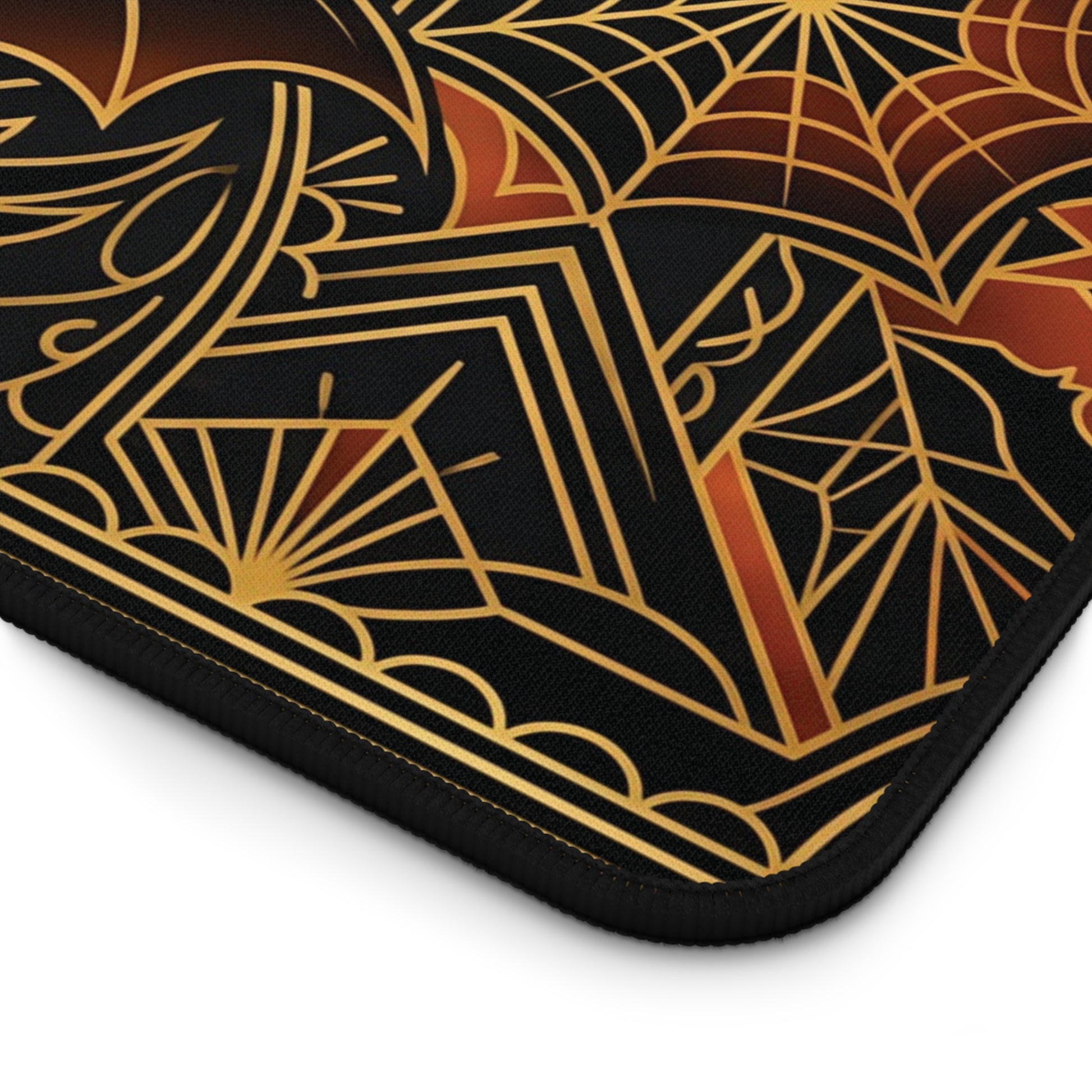 Corner detail of black desk mat with gold spiderweb art deco and orange pumpkin motif