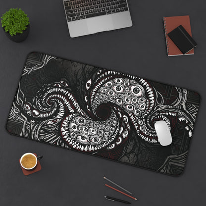 Black desk mat with white and red cosmic tentacle eye design, stitched edge